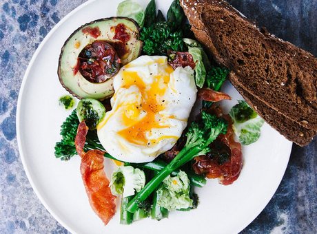Healthy breakfast plate with egg, avocado and greens